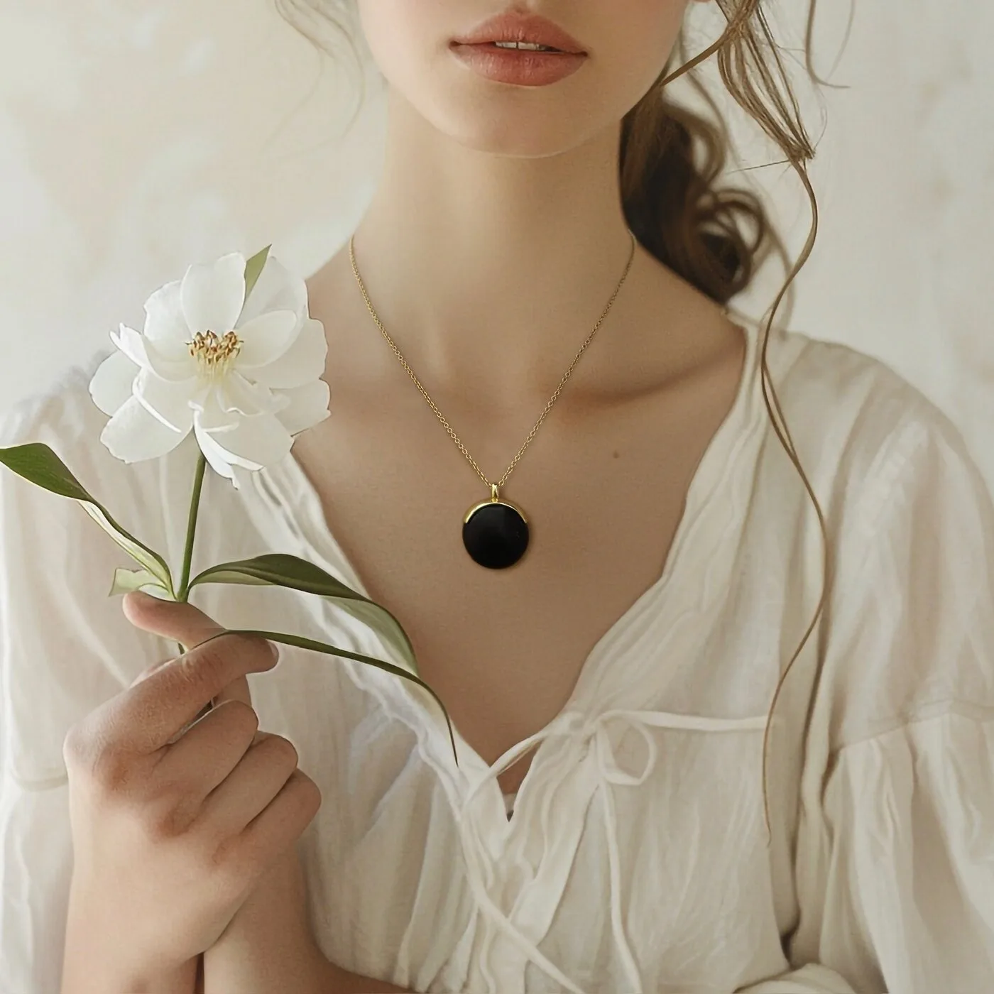 Model wearing Ormiro onyx pendant with white flower